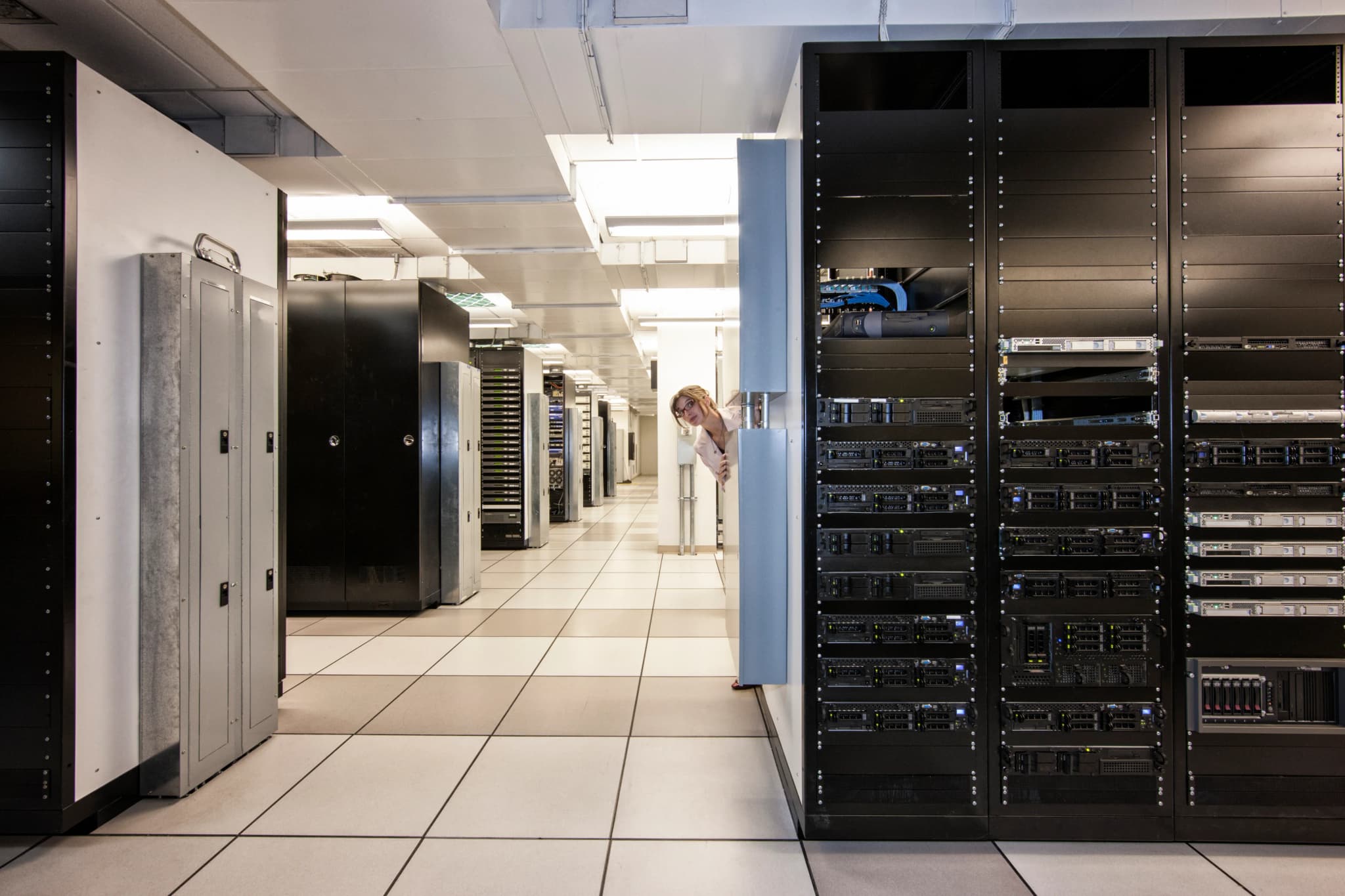 A technician working between server racks in a data center