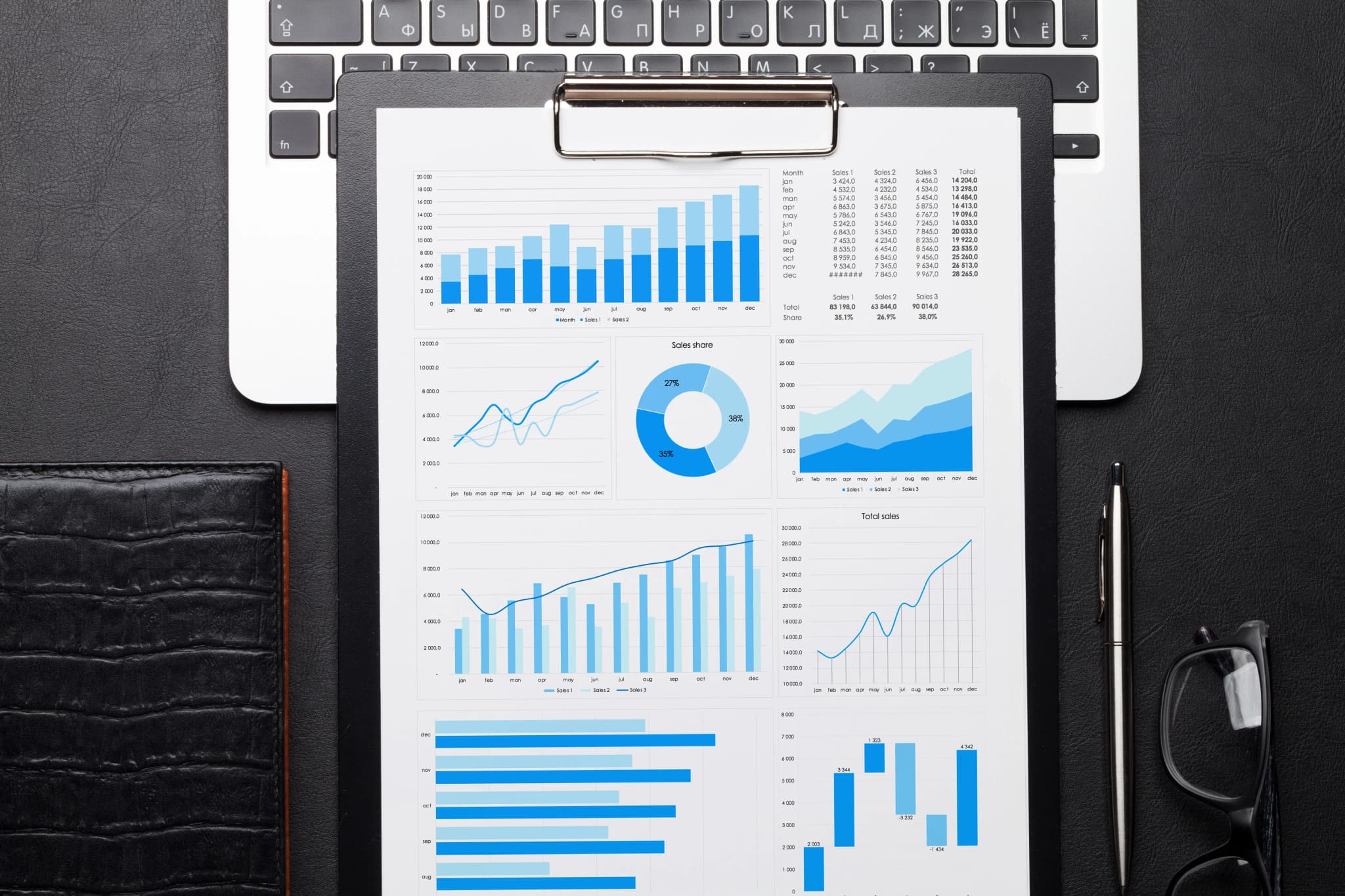 An office desk covered with printed charts and reports