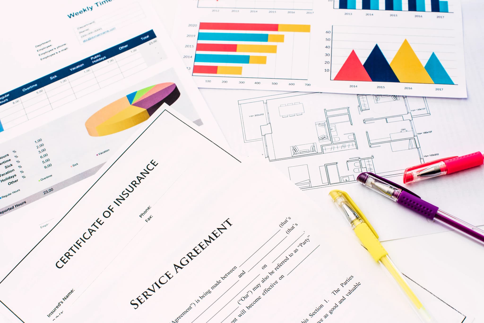 Printed financial documents and cost plans spread across a desk
