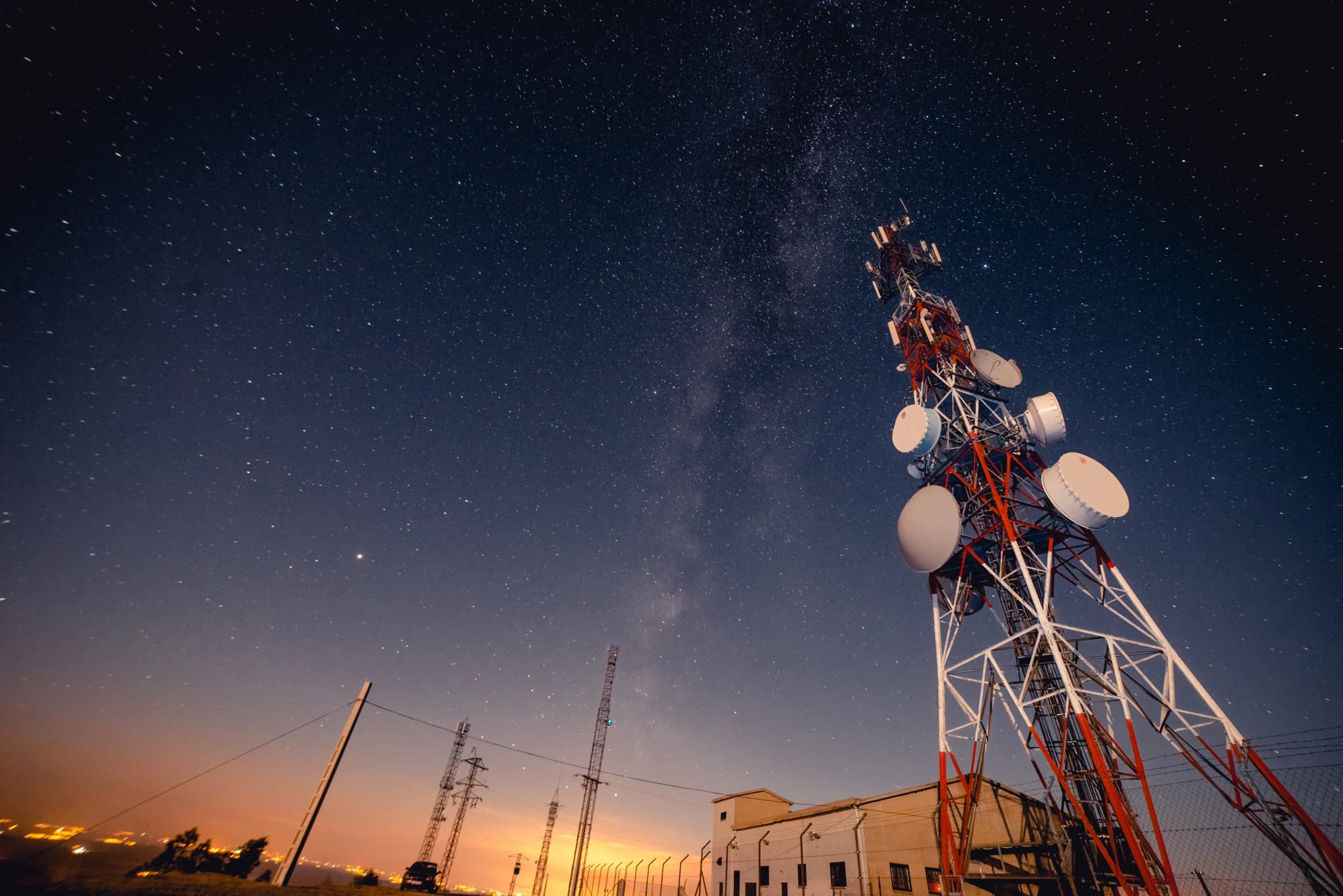 A radio transmission tower silhouetted against a starry night sky